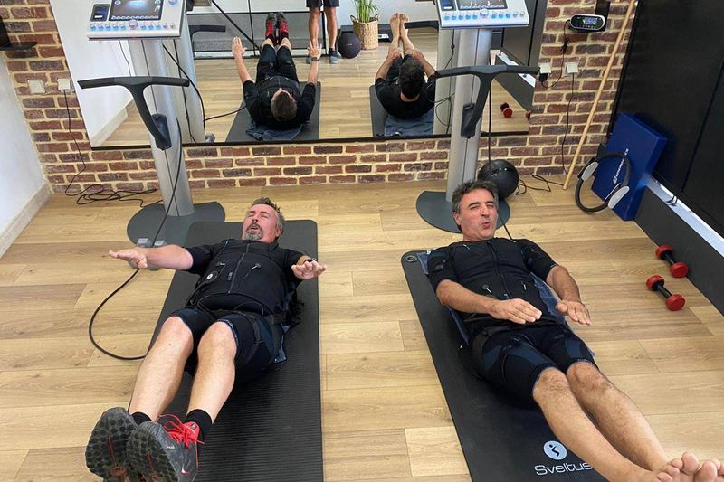 Séance de gainage au sol, en tenue d'électrostimulation